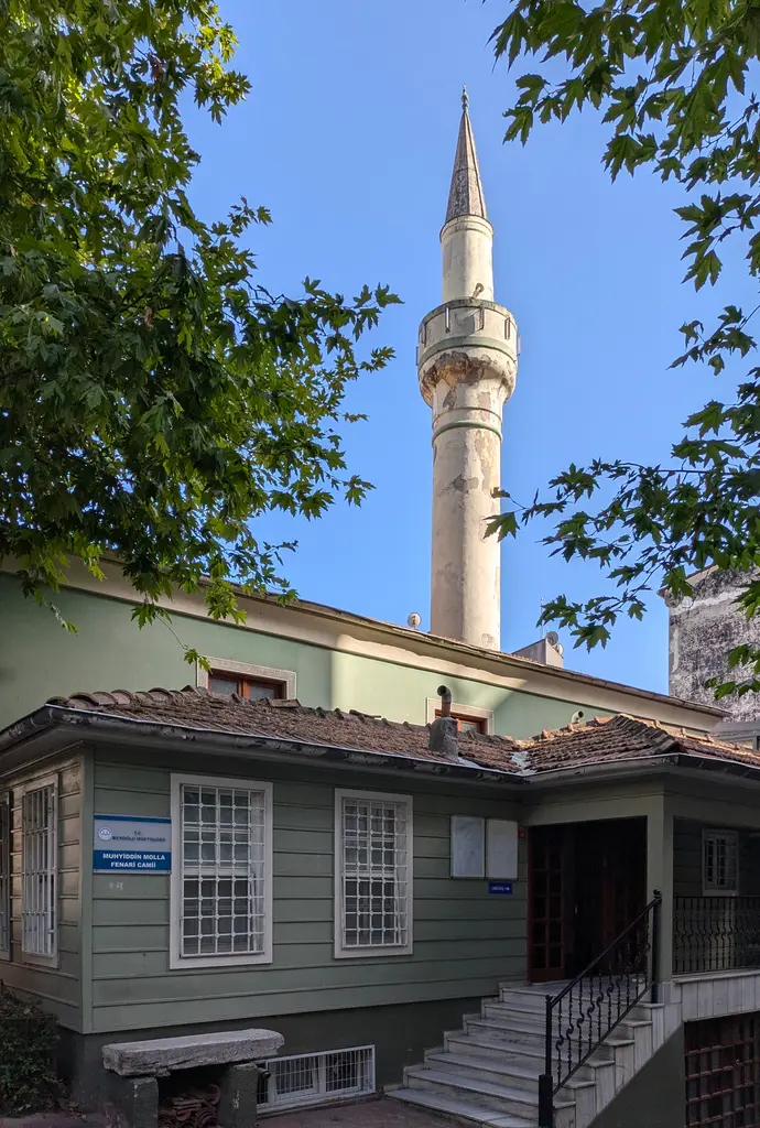 Çukurcuma Camii; ağaçlar arasından yükselen ince taş minare ve önünde yeşil boyalı alçak yapı.