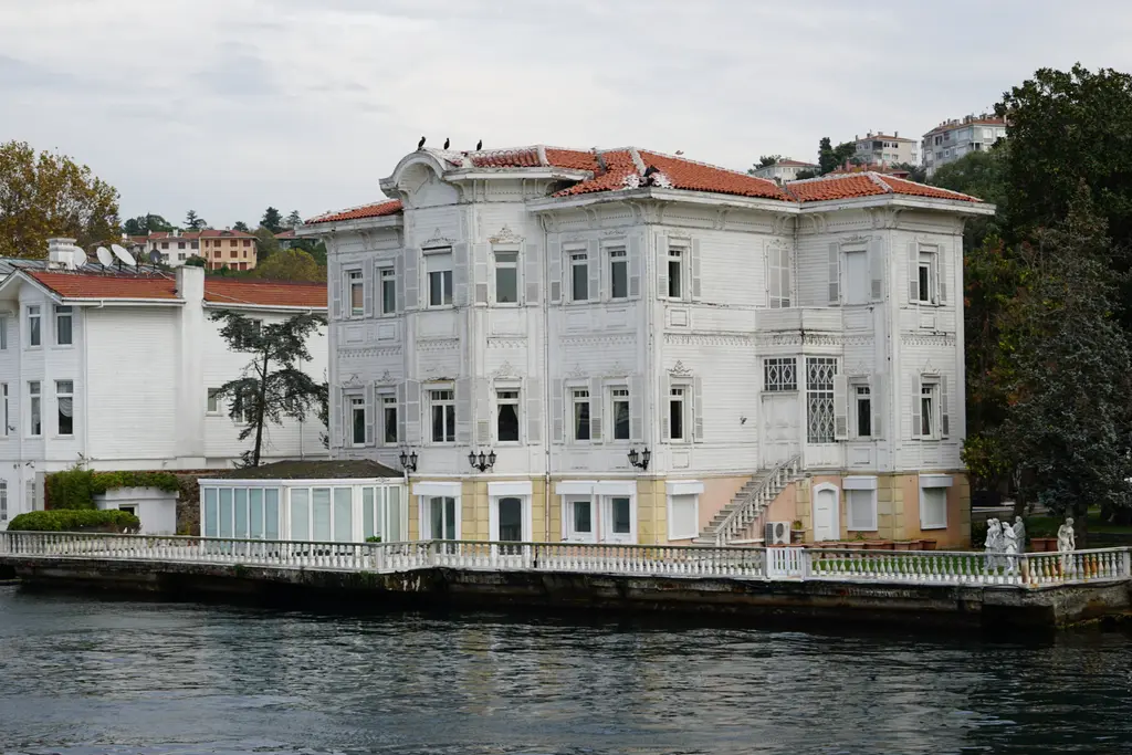 Yağcı Hacı Şefik Bey Yalısı; üç katlı beyaz cephe, sıra pencereler, kiremit çatı ve önde rıhtım.