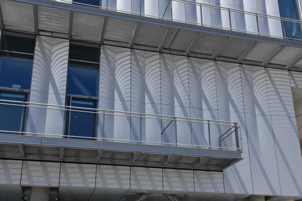İstanbul Modern'in cephesinden yakın görünüm; kavisli, dikey şeritli alüminyum paneller ve altlarında mavi cam bantlar.