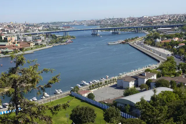 Pierre Loti Tepesi'nden Haliç; ormanlık yamaç, kıyıdaki semtler, Haliç'in kıvrılan suyu ve uzakta tarihi yarımadanın silueti.