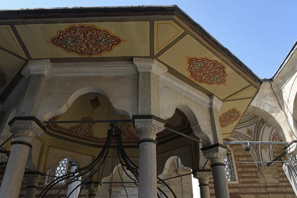 Laleli Camii'nde şadırvanın örtüsü; alttan bakışta boyalı ahşap tavan, bitkisel bezemeli panolar ve sütun başlıkları.