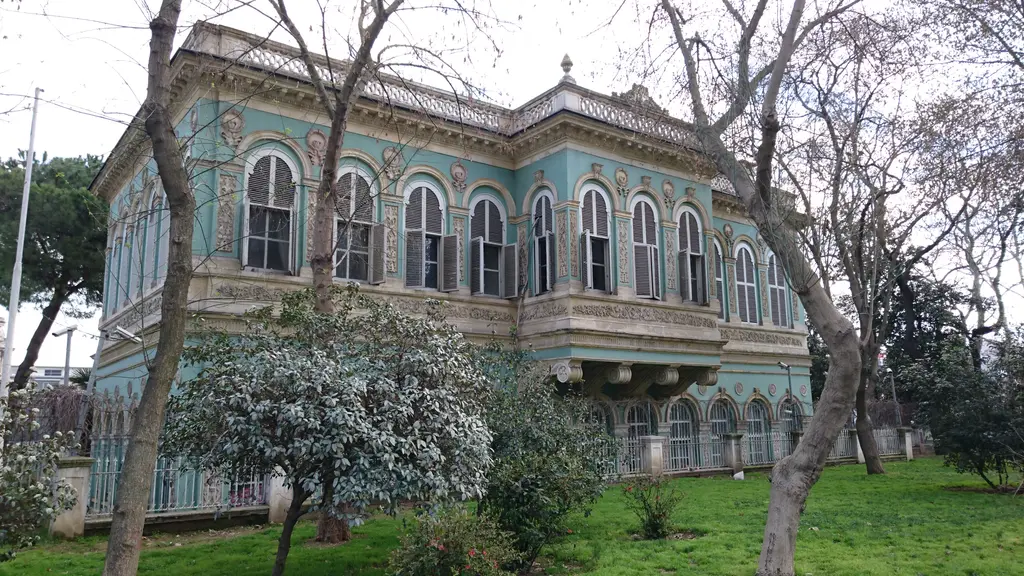 Tophane Kasrı; açık yeşil boyalı iki katlı köşk, kemerli pencereler, önünde çimenlik ve ağaçlar.