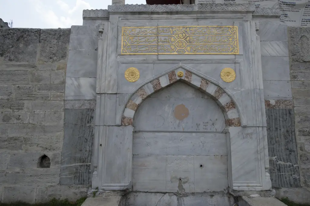 Mihrimah Sultan Çeşmesi; caminin denize bakan duvarına yerleştirilmiş mermer çeşme, kemerli niş ve üstte kitabe.