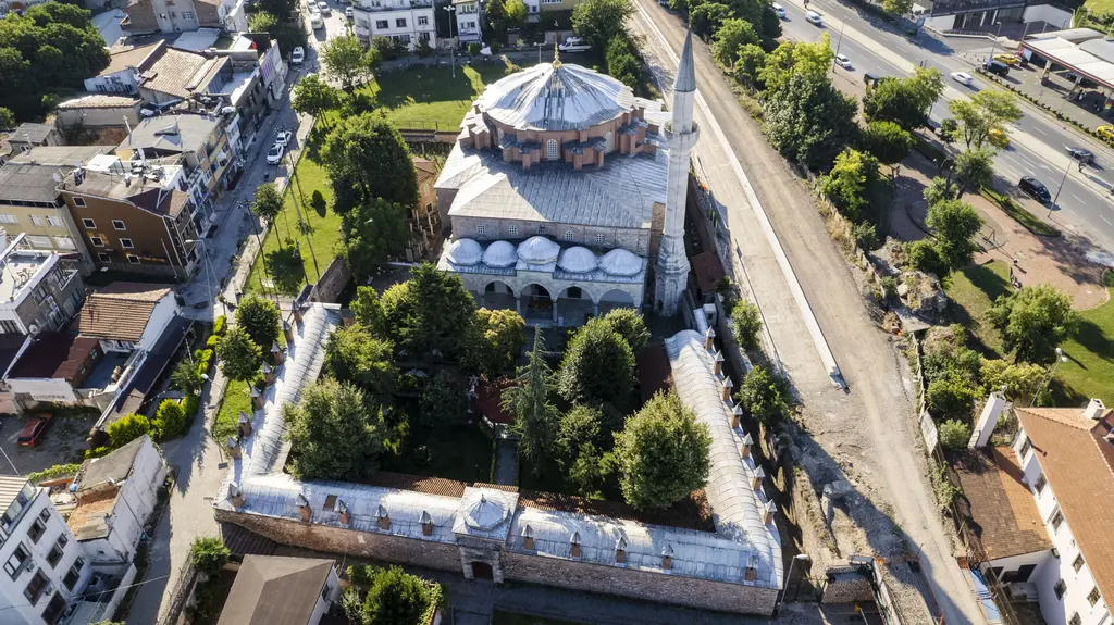 Sultanahmet'te havadan Küçük Ayasofya Camii; ortadaki kubbe, yanındaki minare, avluyu saran alçak yapılar, ağaçlar ve arkada demiryolu hattı.