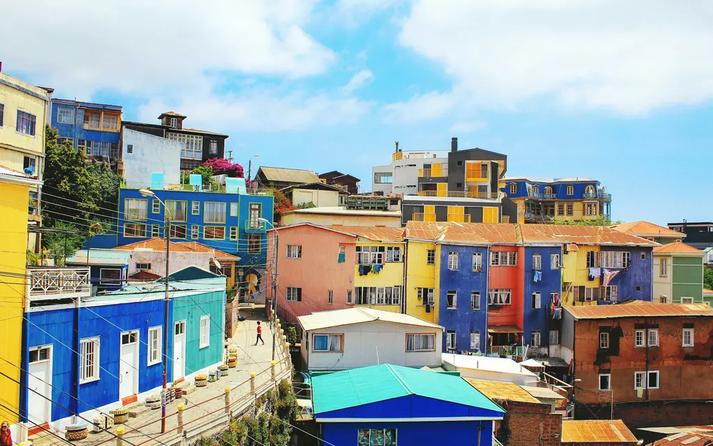 Valparaíso'da yamaç mahalleleri; dik tepelere tırmanan rengârenk boyalı evler ve aşağıdaki liman.
