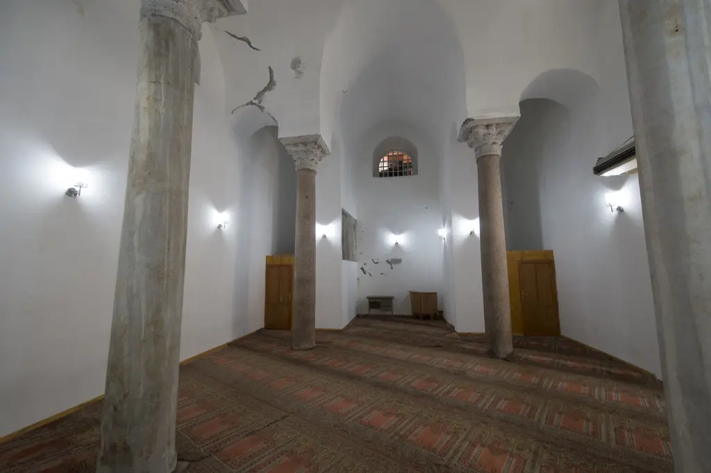 Bodrum Camii'nin alt yapısı geniş açıyla; dört pembe granit sütun, beyaz badanalı tonozlar, dipte kemerli nişte kafesli pencere, yerde seccade desenli halı.