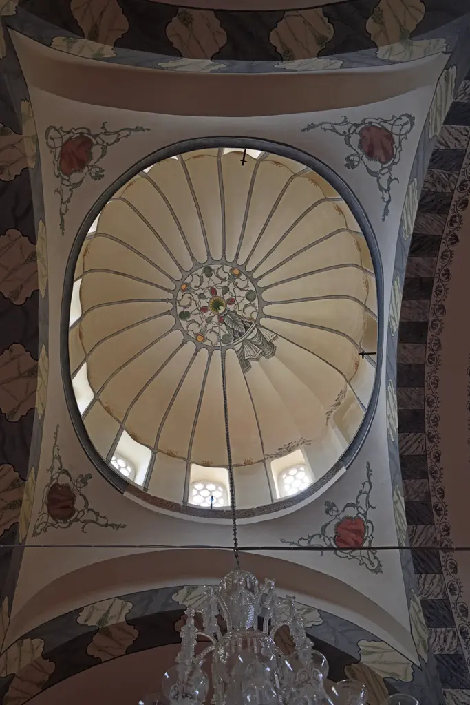 Zeyrek Camii'nin kubbesi içeriden; dilimli kaburgalarla bölünmüş beyaz kubbe, altında kemerli pencereler ve yeşil kırmızı kalem işi bordürler.