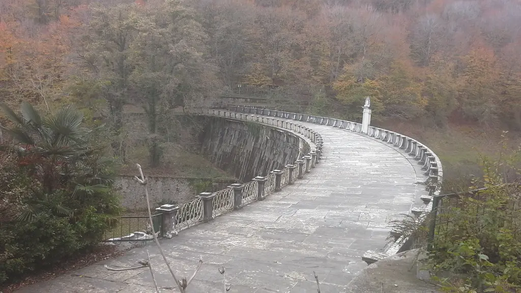 Belgrad Ormanı'nda sisli bir günde bent; kavis çizen taş gövde, ortasında beyaz bir yapı ve iki yanda çıplak ağaçlar.