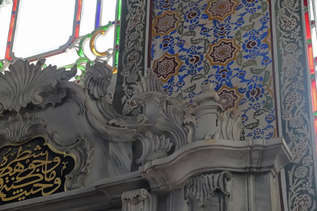 Selimiye Camii'nde duvar süslemesi; mavi ve kırmızı çiçek desenli kalem işi, kemer kenarı ve hat levhası.