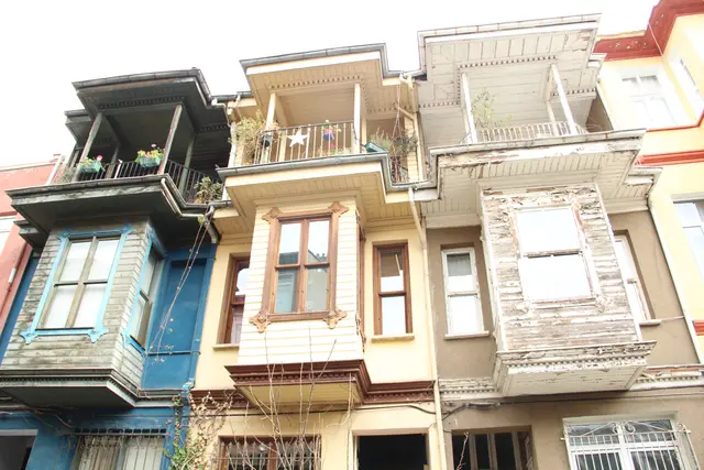 Kuzguncuk'ta yan yana dizilen ahşap evler; mavi, krem ve beyaz cepheler, çıkmalı balkonlar ve kafesli pencereler.