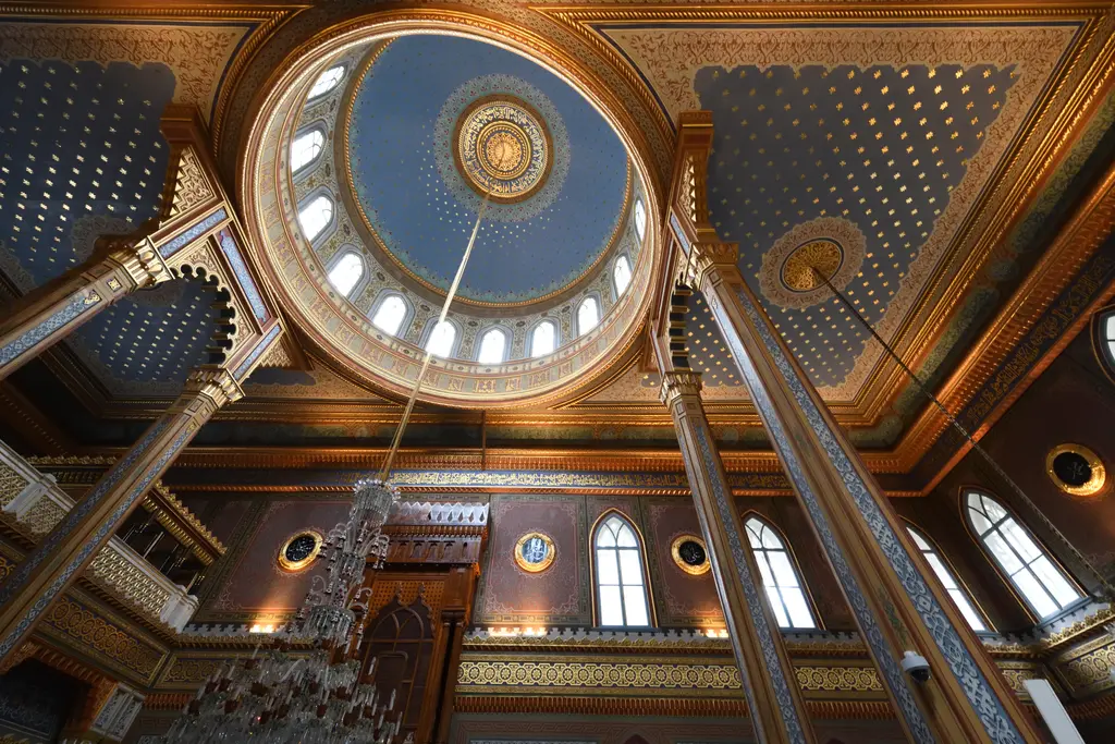 Yıldız Hamidiye Camii'nin kubbesine aşağıdan bakış; pencereli kasnak, yaldızlı kolonlar, yıldızlı tavan ve avize zinciri.