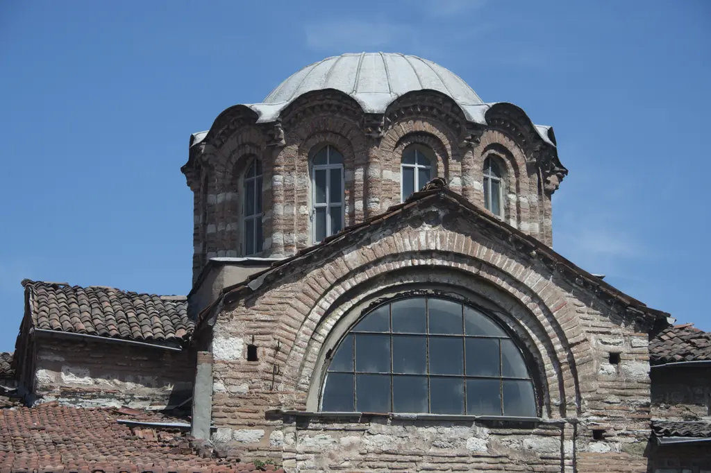 Vefa Kilise Camii'nin batı ucunun üst bölümü öğle güneşinde; kasnak üstünde ana kubbe, gömme sütunçeler arasında kemerli pencereler ve önde büyük yarım daire kemerli alınlık penceresi.