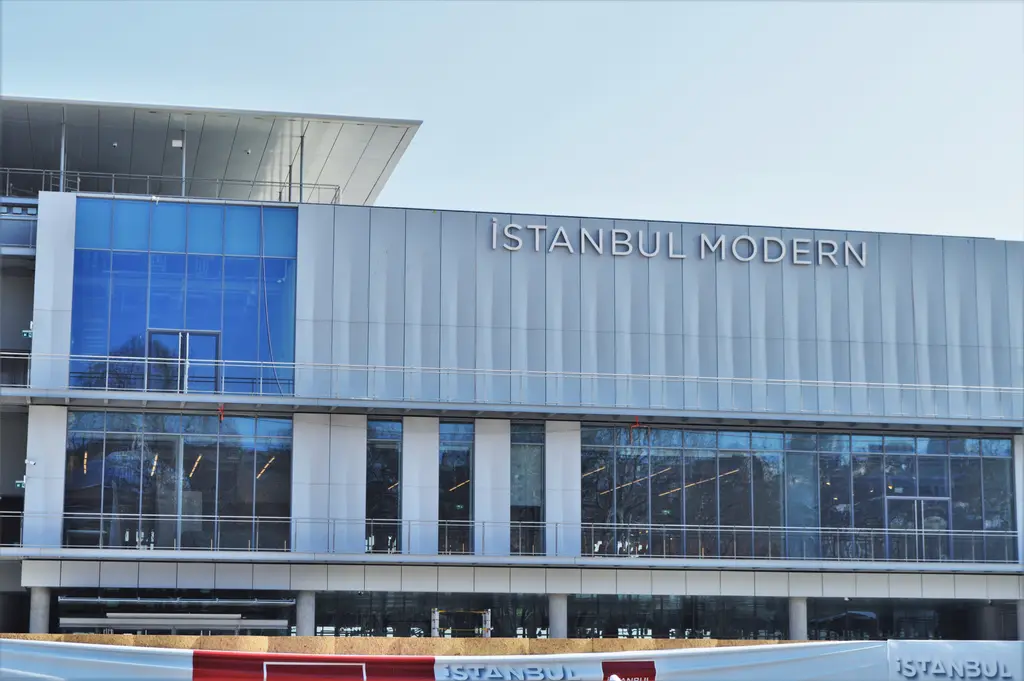 İstanbul Modern'in cephesi; mavi camlı alt kat, üstünde "İSTANBUL MODERN" yazılı açık gri alüminyum kaplama.