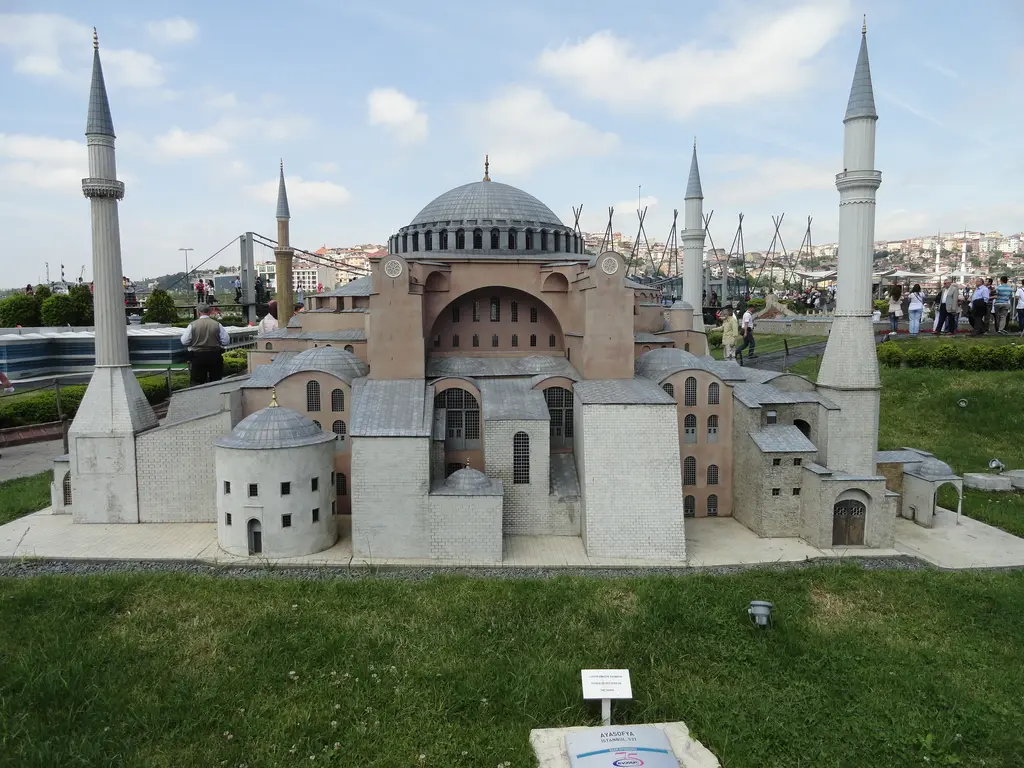 Miniatürk'te Ayasofya maketi; pembemsi duvarlar, gri ana kubbe, dört açık renkli minare, önünde çimen ve küçük bilgi kartı.