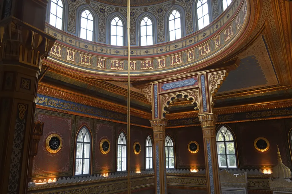 Yıldız Hamidiye Camii'nin kubbe kasnağı; sivri kemerli pencereler, yazı kuşağı, yuvarlak levhalar ve yaldızlı kolon başlıkları.