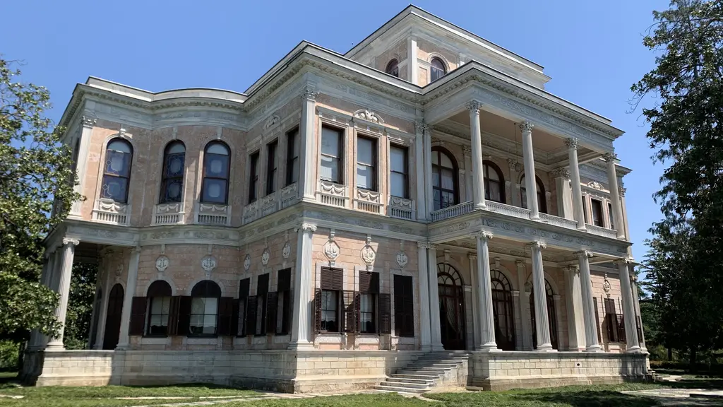 Beykoz Kasrı; iki katlı beyaz neoklasik cephe, sütunlu revak, yüksek pencereler ve önünde çimenlik.