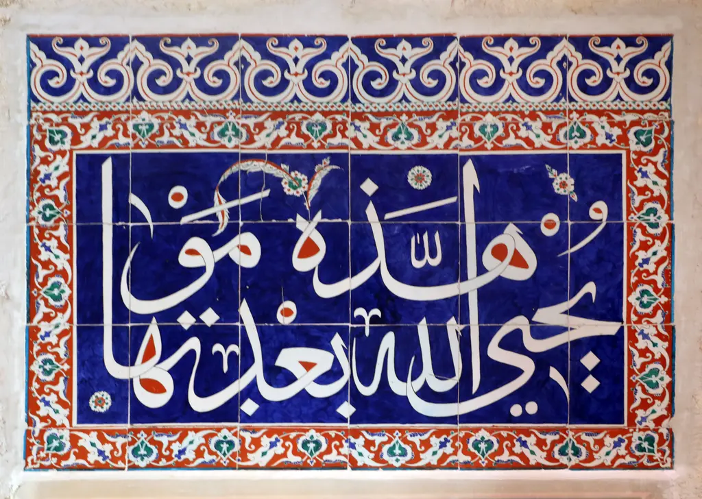Kılıç Ali Paşa Camii'nde bir İznik çini panosu; lacivert zeminde beyaz harfli ayet, kırmızı ve yeşil çiçeklerle bezeli beyaz bordür.