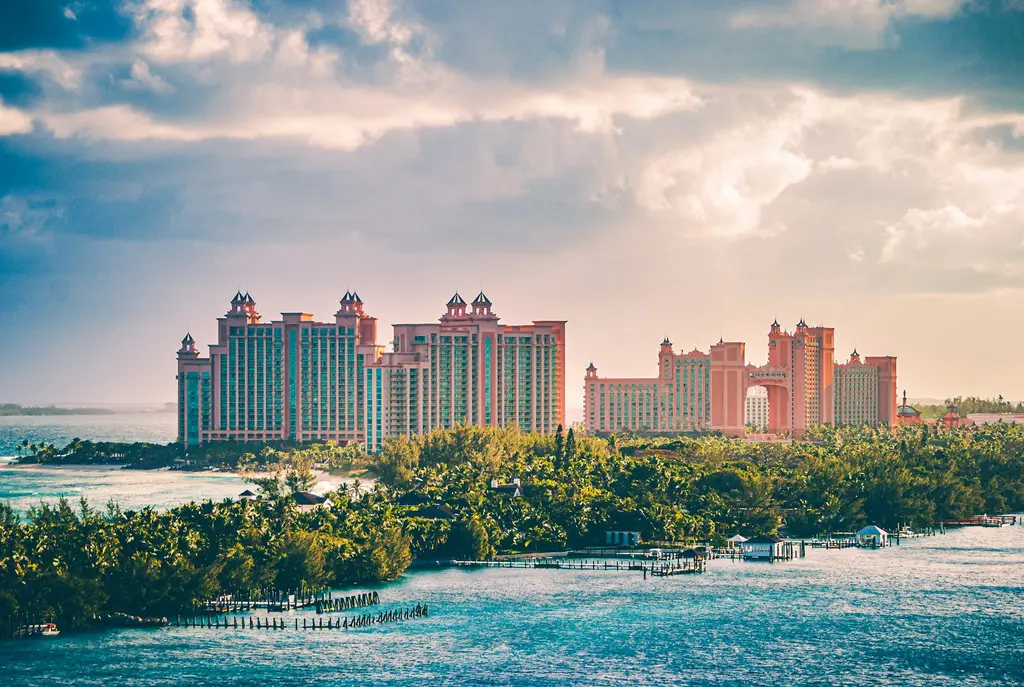 Bahamalar'ın başkenti Nassau'da Paradise Island; pembe kuleli dev Atlantis tatil kompleksi, önünde palmiyeli yeşillik ve iskeleler.