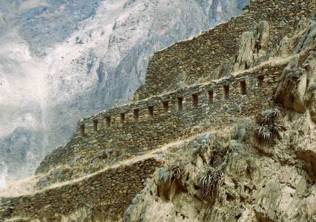 Ollantaytambo'da İnka kalesi; yamaca basamak basamak yükselen taş teraslar ve tepedeki tapınak kalıntıları.