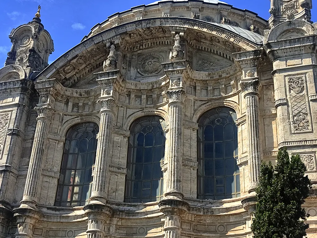 Ortaköy Camii'nin cephesinden ayrıntı; büyük kemerli pencereler, oymalı taş süslemeler, yivli sütunlar ve kemer üstü bezemeler.