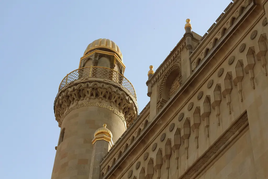 Bakü'de Təzəpir Camii; oymalı taş süslemeleri, şerefesi işlemeli minaresi ve açık gökyüzüne karşı uzanan cephe silmeleri.