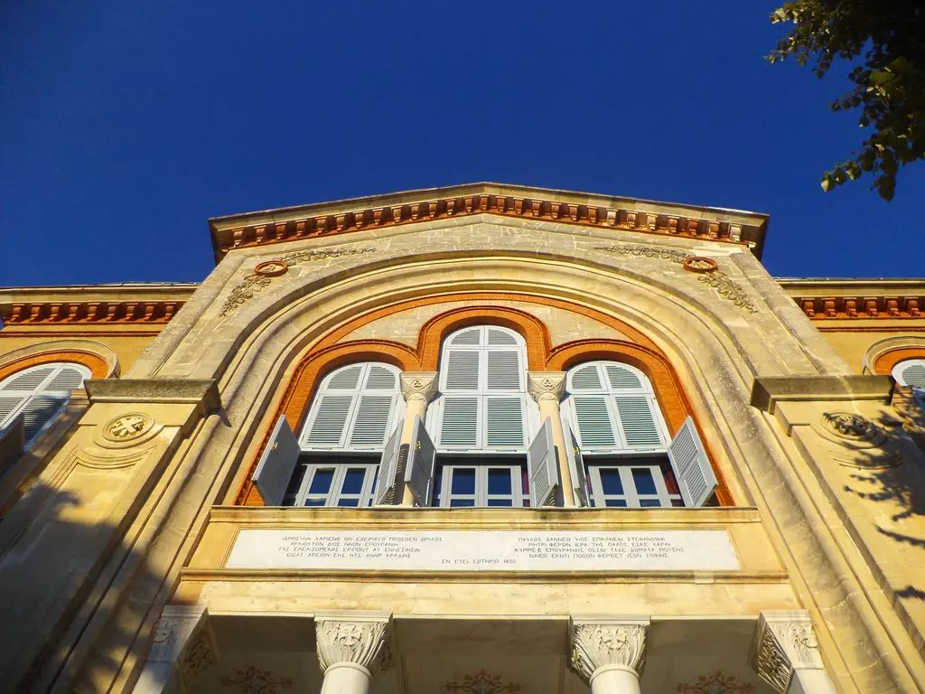 Heybeliada Ruhban Okulu'nun cephesi; sarı sıvalı simetrik bina, kemerli pencereler ve alınlıklı giriş.