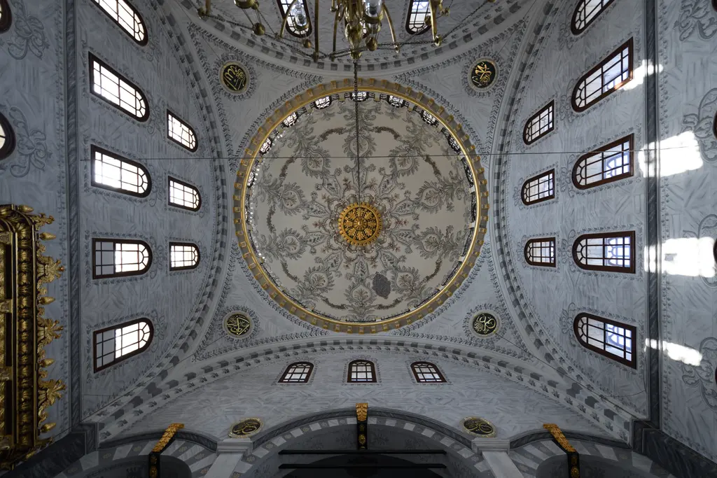 Nusretiye Camii'nin kubbesi içeriden; ortada yaldızlı bitkisel göbek, çevresinde kalem işi bezemeler ve kasnaktaki pencere dizisi.
