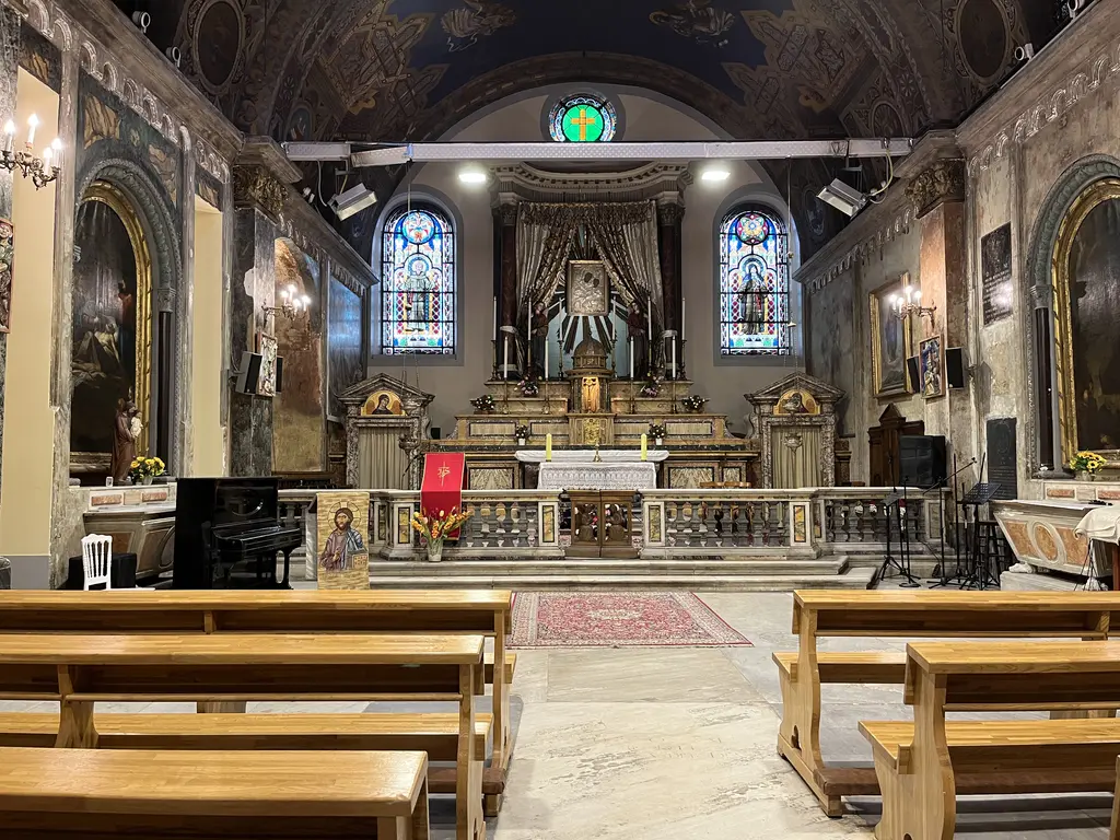 Sent Antuan Kilisesi'nde altar bölümü; mermer altar, yanlarda heykeller, arkada koro sıraları ve renkli camlı pencereler.