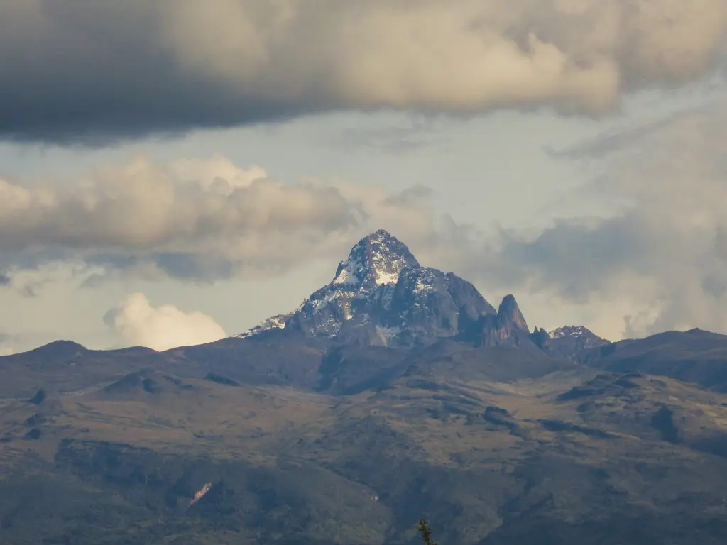Mount Kenya; karlı-buzullu sivri zirvesi ve çevresindeki dağ bitki örtüsü.