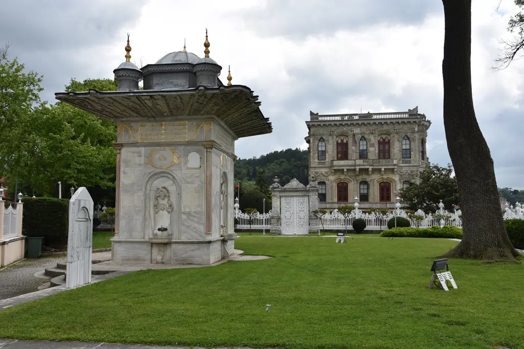 Küçüksu'da Mihrişah Valide Sultan Çeşmesi; geniş saçaklı dört cepheli mermer çeşme, çimenlik çayır ve arkada kasır.