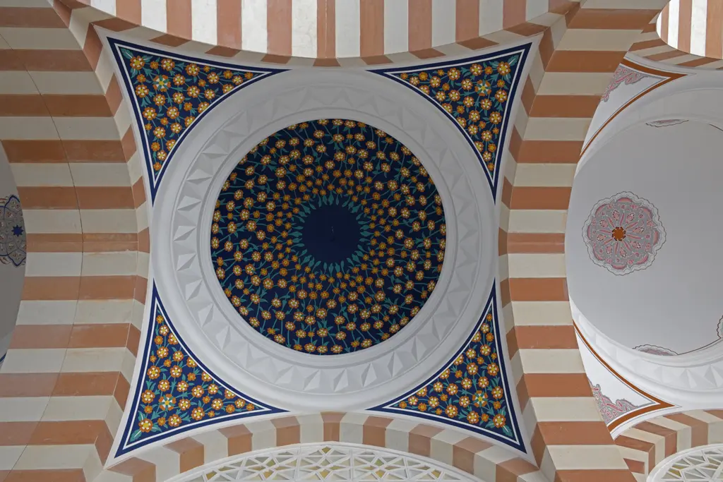 Büyük Çamlıca Camii'nde revak kubbesi; lacivert ve altın desenli kubbe, kırmızı beyaz kemerler.