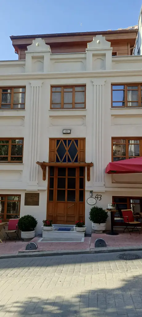 Çukurcuma Hamamı'nın restore edilmiş cephesi; beyaz ve krem renkli taş duvar, ahşap kapı ve kemerli pencereler.