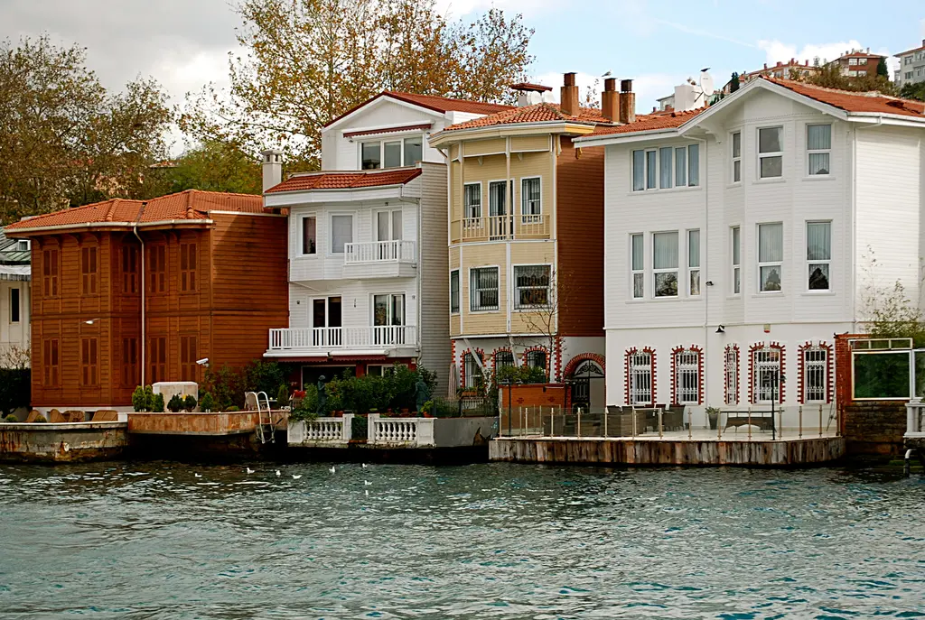 Kanlıca kıyısında yan yana yalılar; kırmızı ahşap, beyaz ve krem cepheler, kiremit çatılar ve suya inen rıhtım.