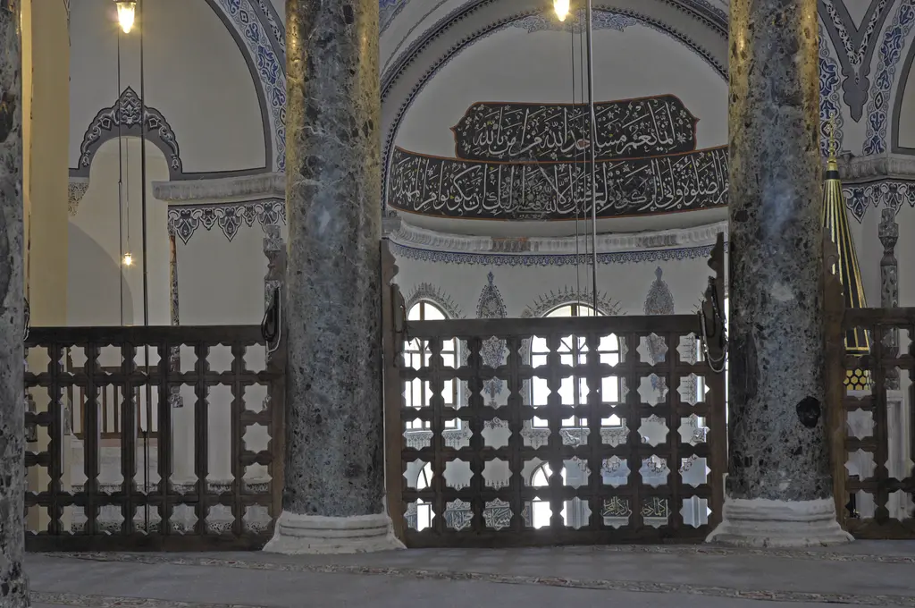 Küçük Ayasofya Camii'nde hünkâr mahfilinin şebekesi; iki benekli gri yeşil mermer sütun arasında yıldız çokgen delikli oyma taş kafes, üstünde hat panosu ve kalem işi bordürler.