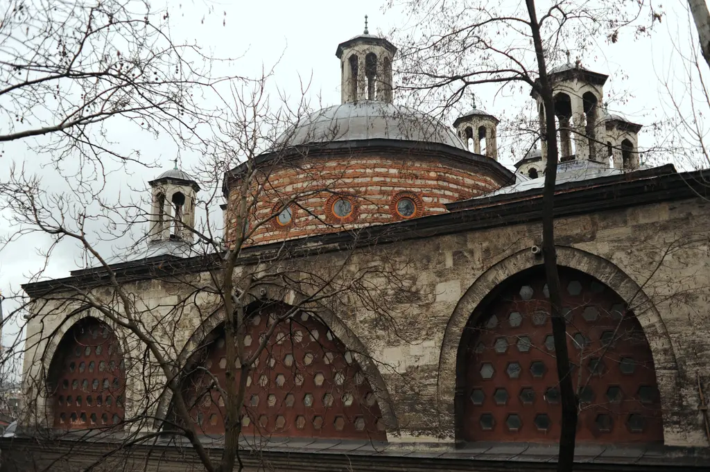 Tophane-i Âmire'nin kemerli cephesi; demir parmaklıklı büyük kemerler, üstte kubbe ve önünde yapraksız ağaçlar.