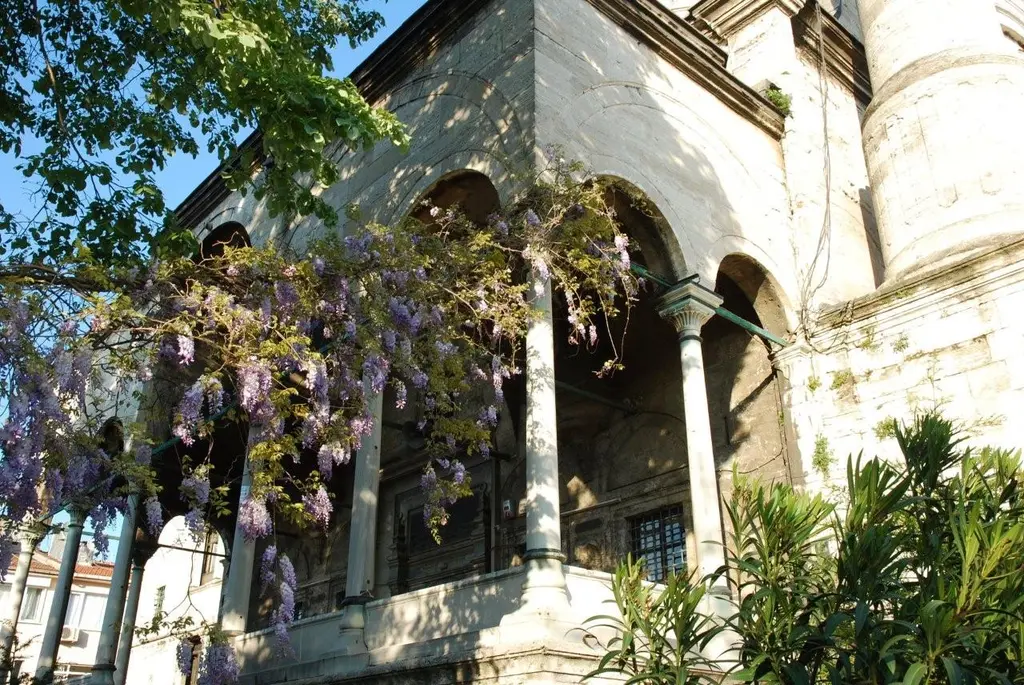 Ayazma Camii'nde hünkâr köşkünün revakı; mor salkımlı sarmaşık, kemerler, ince sütunlar ve yeşil bitkiler.