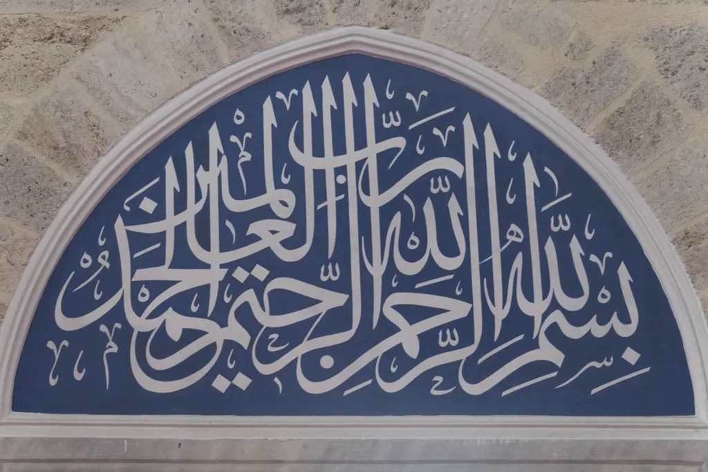 Mihrimah Sultan Camii'nde kemer alınlığındaki pano; lacivert zemin üzerine beyaz iri hatla yazılmış yazı ve çevresini dolanan ince bordür.