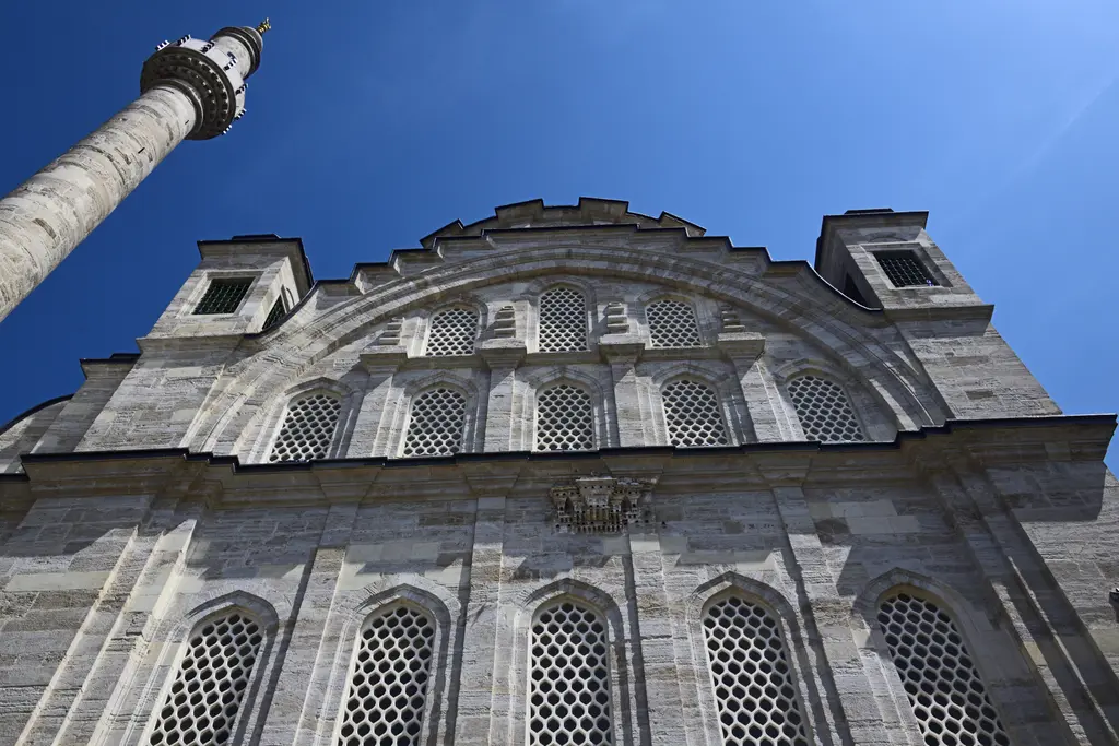 Ayazma Camii'nin cephesi; büyük kemerin içinde sıra sıra pencereler, köşelerde kuleler ve yanda yükselen minare.