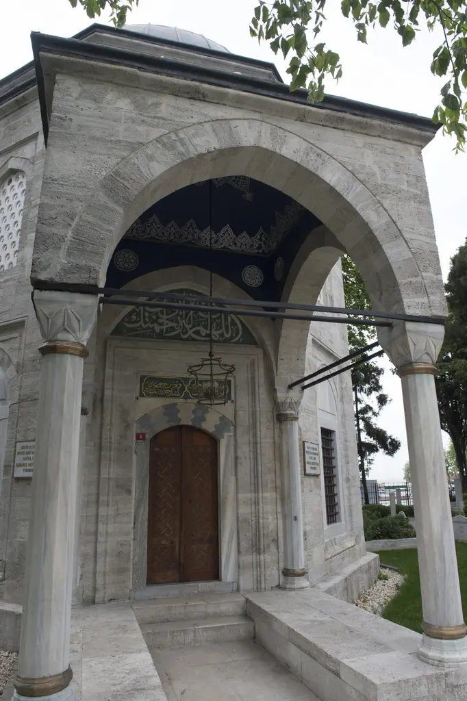 Barbaros Hayreddin Paşa Türbesi'nin revakı; mermer sütunlara oturan sivri kemerler, ortada ahşap kapı ve üstünde kitabe.