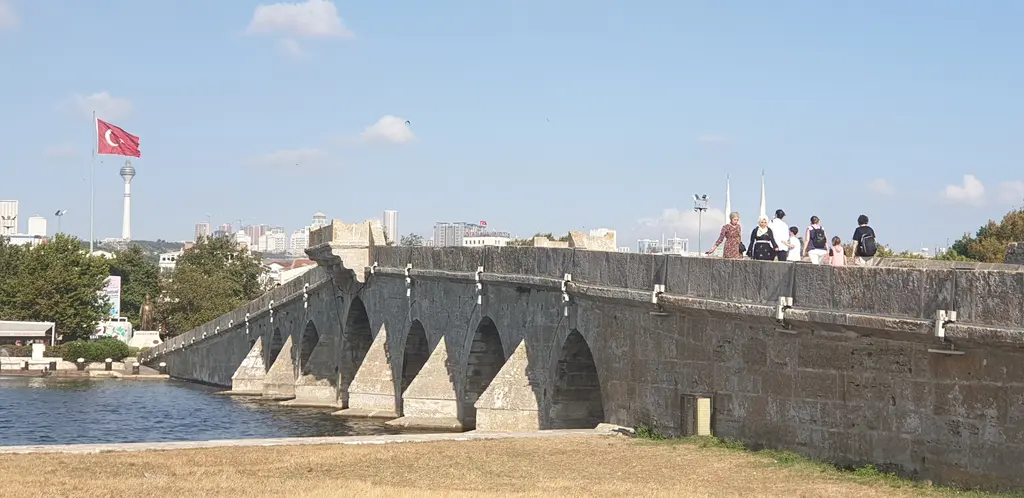Büyükçekmece'de Kanuni Sultan Süleyman Köprüsü; sıra sıra taş kemerler, köprü sırtında yürüyen insanlar ve bayrak direği.