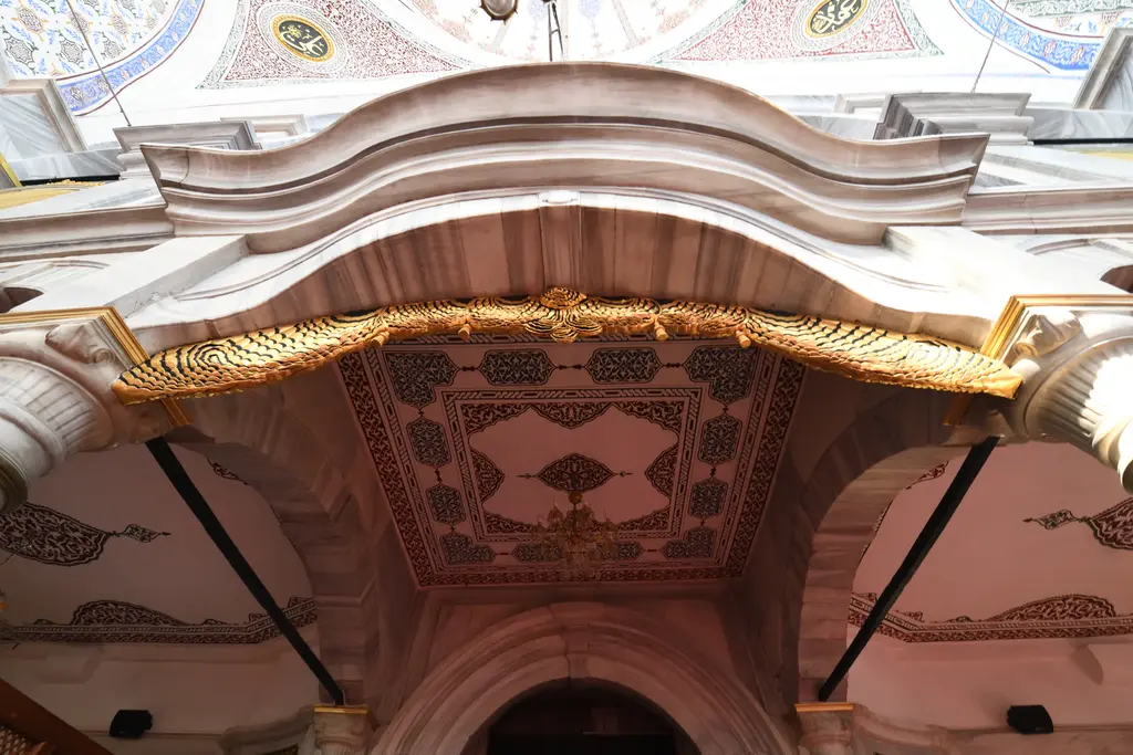 Selimiye Camii'nde giriş üstündeki mahfil; mermer kemer, altın yaldızlı saçak süslemesi ve arkada pencereler.
