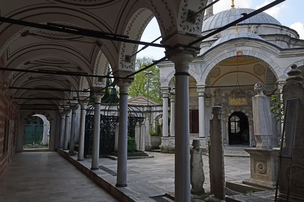 Mihrişah Valide Sultan Külliyesi'nde revak; kalem işi tonozlar, ince sütunlar, mezar taşları ve sağda türbenin revaklı girişi.