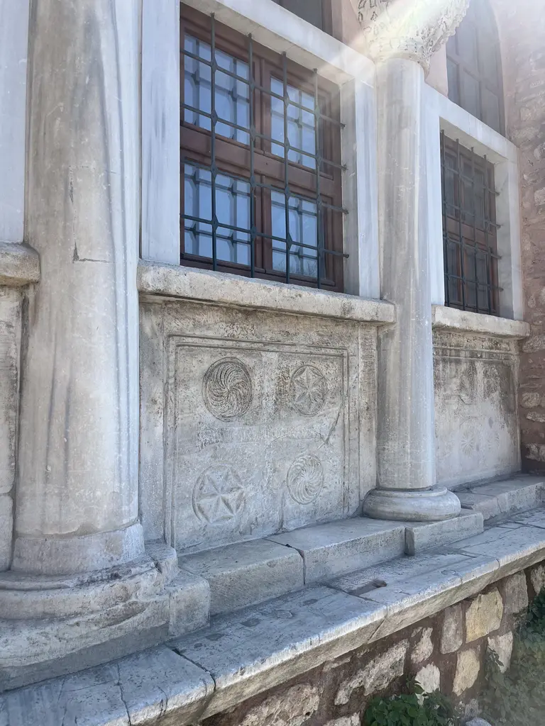 Vefa Kilise Camii'nin revak sekisinde iki beyaz mermer sütunçe; profilli kaideler, arkada baklava desenli parmaklıklı ahşap pencereler, aralarında rozetli ve yıldızlı mermer levha.