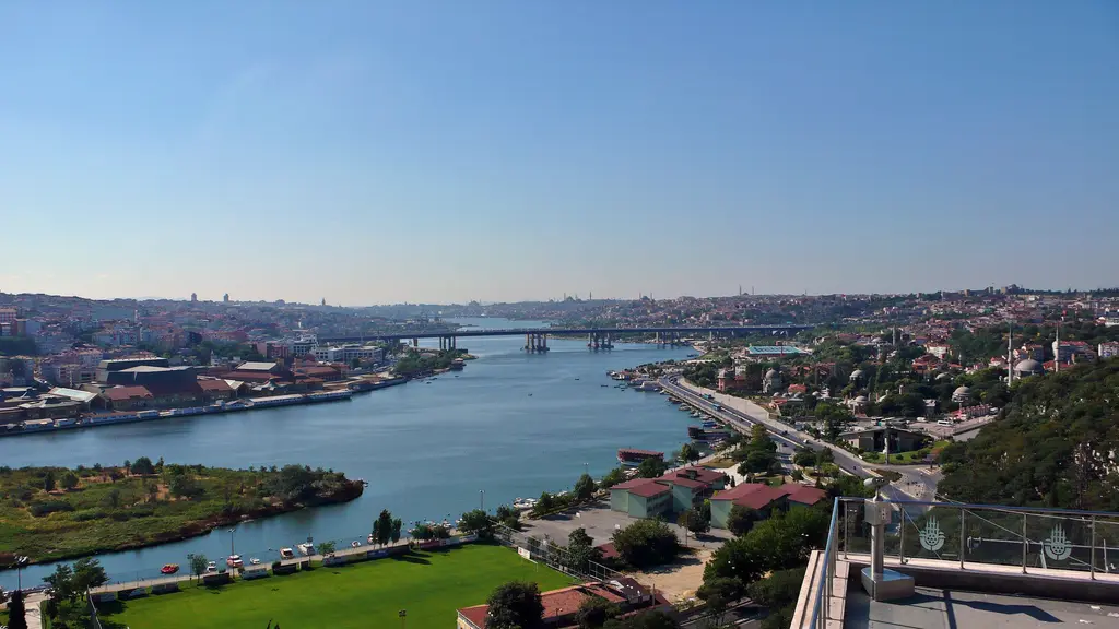 Pierre Loti Tepesi'nden Haliç manzarası; yeşil yamaçlar, kıyıdaki semtler, adacıklar ve ufukta silik kent silueti.