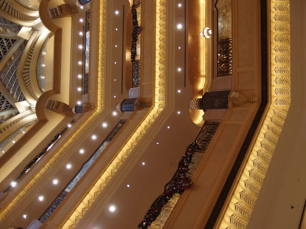 Abu Dabi'de Emirates Palace; kubbeli görkemli otel yapısı ve önündeki bahçeler.
