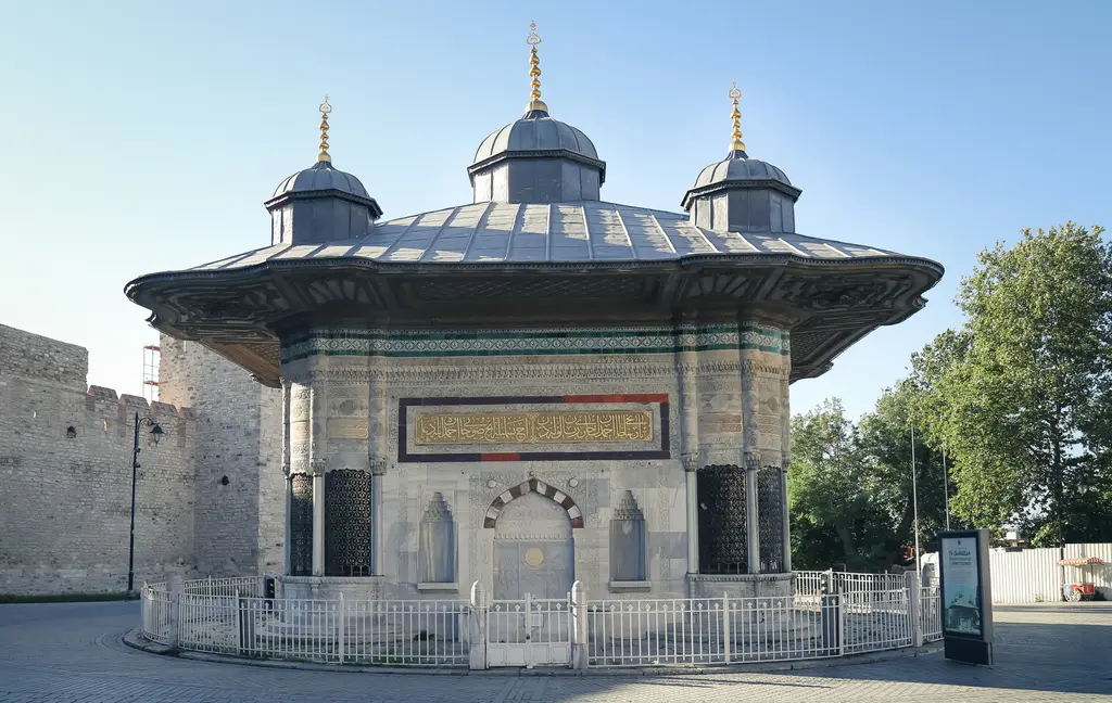 III. Ahmet Çeşmesi; kare planlı mermer gövde, geniş saçaklı kurşun çatı, tepesinde beş kubbecik ve çevresinde alçak demir parmaklık.