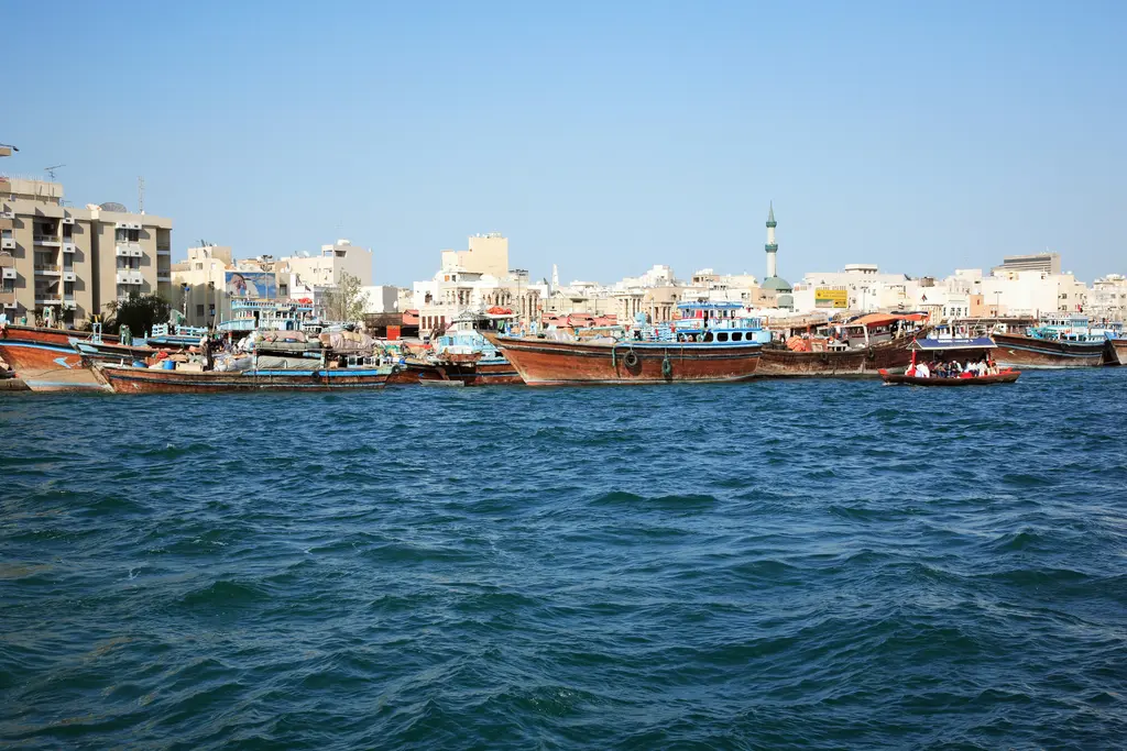Dubai Deresi'nde geleneksel ahşap tekneler; suda bekleyen dhow'lar ve arkadaki gökdelenler.
