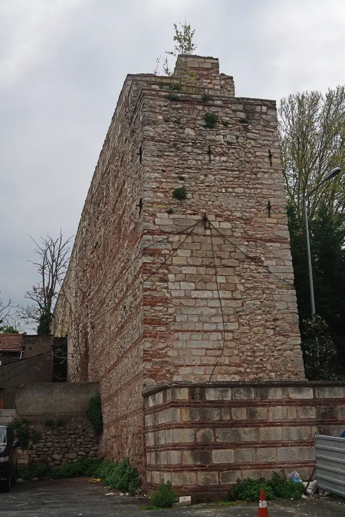 Bozdoğan Kemeri'nin son bulduğu uç ayak; yukarı doğru daralan masif taş kütle, blokların arasında kalın kırmızı tuğla kuşakları, tepesinde kendiliğinden bitmiş bir fidan.