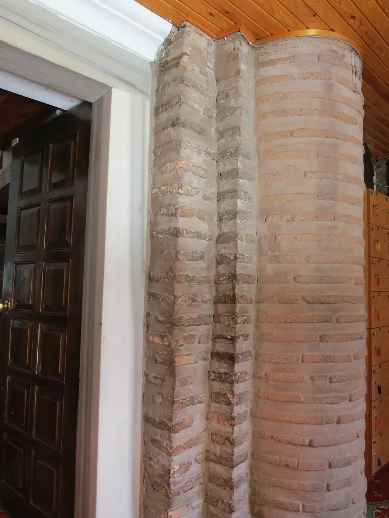 Bodrum Camii'nin narteksinde sıvası açık bırakılmış yarım daire gömme payanda; sıra sıra tuğla ile moloz taşın almaşık örgüsü, üstte ahşap tavan, sağda ayakkabı dolapları.