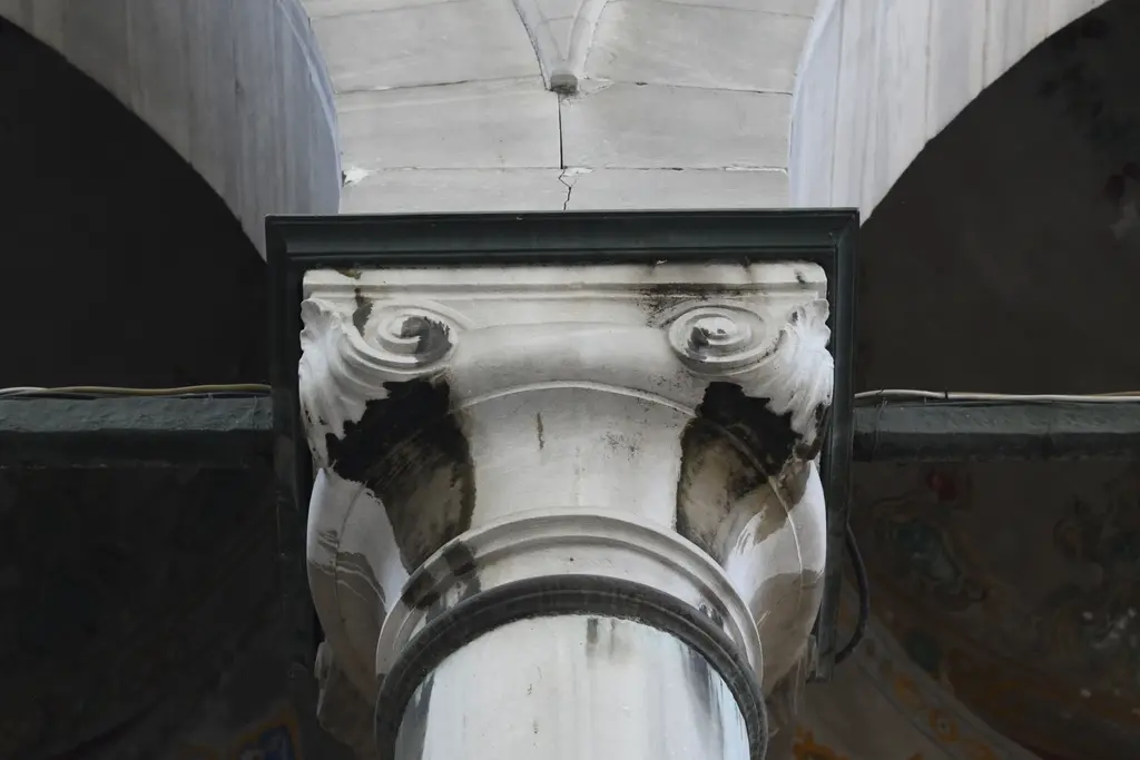 Eyüp Sultan Camii'nde sütun başlığı; aşağıdan bakışla kıvrımlı barok başlık, mermer gövde ve kemer.